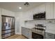 Close-up view of the kitchen with stainless steel appliances and grey lower cabinets with white uppers at 1263 W Devonshire St, Mesa, AZ 85201
