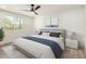 Bright bedroom with a large window, ceiling fan, neutral walls, and a comfortable bed with blue accents at 1313 N 71St St, Scottsdale, AZ 85257