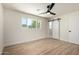 Bedroom with wood-look floors, bright window, ceiling fan, and a stylish sliding barn door at 1313 N 71St St, Scottsdale, AZ 85257