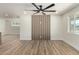 Empty living room with wood panel accent wall, ceiling fan, and a window with natural light at 1313 N 71St St, Scottsdale, AZ 85257