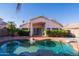 A backyard pool with a rock waterfall feature, landscaping, and a view of the house at 1463 W Mead Dr, Chandler, AZ 85248