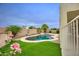 Private backyard boasts a pool, spa, lush landscaping, artificial grass, and space for entertaining guests at 14823 W Windsor Ave, Goodyear, AZ 85395