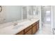Bathroom with double sink vanity, tile floors, large mirror, and a walk-in shower is bright and spacious at 14823 W Windsor Ave, Goodyear, AZ 85395