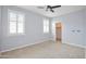 Light and airy bedroom with carpet, ceiling fan, white shutters, and pale blue walls leads to walk-in closet at 14823 W Windsor Ave, Goodyear, AZ 85395