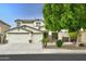 Two-story home with desert landscaping, a three-car garage, and stone accents, combining modern design and desert charm at 14823 W Windsor Ave, Goodyear, AZ 85395