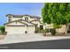 Two-story home featuring a three-car garage, desert landscaping, stone accents and a charming outdoor seating area at 14823 W Windsor Ave, Goodyear, AZ 85395