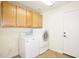 Functional laundry room with upper cabinets and modern washer and dryer at 14823 W Windsor Ave, Goodyear, AZ 85395