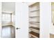 Bright, open linen closet with five shelves offers great storage with bathroom entrance and bedroom in the background at 14823 W Windsor Ave, Goodyear, AZ 85395