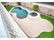 Aerial view of a private backyard pool with an attached spa, surrounded by lush green landscaping at 14823 W Windsor Ave, Goodyear, AZ 85395