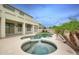 Backyard features a pool, raised spa, palm trees and neutral patio, perfect for outdoor enjoyment and relaxation at 14823 W Windsor Ave, Goodyear, AZ 85395
