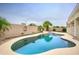 A backyard swimming pool and spa are surrounded by a block wall with lovely plants and palm trees at 14823 W Windsor Ave, Goodyear, AZ 85395