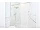 Modern tiled walk-in shower features rainfall shower head, glass doors and a mosaic tile floor at 14823 W Windsor Ave, Goodyear, AZ 85395