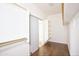 Walk-in closet featuring open shelving, sliding closet door, and laminate wood floors at 14823 W Windsor Ave, Goodyear, AZ 85395