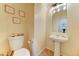 Traditional bathroom with pedestal sink, toilet, and framed seashell art on the walls at 17009 S Coleman St, Phoenix, AZ 85045