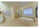 Primary bathroom featuring bathtub, glass shower enclosure, and window at 17009 S Coleman St, Phoenix, AZ 85045