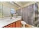 Cozy bathroom features a vanity with sink and a toilet with a black and white checkered shower curtain at 17009 S Coleman St, Phoenix, AZ 85045