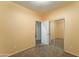 Bedroom with neutral-colored walls and carpet, featuring sliding closet doors and an open doorway at 17009 S Coleman St, Phoenix, AZ 85045