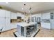 Well-lit kitchen with a central island, white cabinetry, and stainless steel appliances at 17009 S Coleman St, Phoenix, AZ 85045