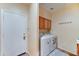 A laundry room with washer, dryer, and cabinets for storage, as well as a door at 17009 S Coleman St, Phoenix, AZ 85045