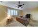 Comfortable carpeted living room featuring a ceiling fan, couch, and a large window at 17009 S Coleman St, Phoenix, AZ 85045