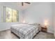 Cozy bedroom features a ceiling fan, wood flooring, and natural light from a large window at 1701 E Colter St # 151, Phoenix, AZ 85016