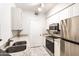 Stylish kitchen with stainless steel appliances, white cabinets, and granite countertops, providing a modern culinary space at 1701 E Colter St # 151, Phoenix, AZ 85016