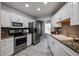 Well-equipped kitchen featuring white cabinets, stainless steel appliances, and functional layout at 17238 N 107Th Ave, Sun City, AZ 85373