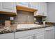 Kitchen sink and countertop area with white cabinetry and decorative touches at 17238 N 107Th Ave, Sun City, AZ 85373