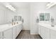 Bright bathroom featuring double sink vanity with white cabinets and wood-look tile flooring at 22499 E Mewes Rd, Queen Creek, AZ 85142