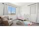 Bedroom features a comfortable chair, a window, a crib and plenty of play space at 22499 E Mewes Rd, Queen Creek, AZ 85142