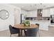 Elegant kitchen with white cabinets, stainless steel appliances, and a stylish dining area at 22499 E Mewes Rd, Queen Creek, AZ 85142