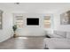 Bright living room with wood-look tile floors and a comfortable gray sectional sofa at 22499 E Mewes Rd, Queen Creek, AZ 85142