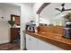 Features a wooden bar with a built-in coffee machine, situated beneath a rustic brick archway and white cabinetry at 2908 E Pinchot Ave, Phoenix, AZ 85016