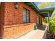 Close-up of exterior brick wall with windows and green trim, showing architectural details and landscaping at 2908 E Pinchot Ave, Phoenix, AZ 85016