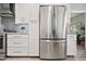 A stainless steel refrigerator is framed by white cabinets, set against a stylish gray backsplash and granite countertops at 2908 E Pinchot Ave, Phoenix, AZ 85016