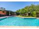 View of the large backyard swimming pool with brick patio and lush landscaping, ideal for summer fun at 2908 E Pinchot Ave, Phoenix, AZ 85016