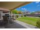 Backyard featuring green grass, covered patio, and block wall for privacy at 2911 W Keim Dr, Phoenix, AZ 85017
