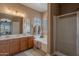 Bathroom featuring double sinks, vanity, a soaking tub, and a glass-enclosed shower at 2911 W Keim Dr, Phoenix, AZ 85017