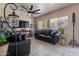 Inviting living area featuring a comfortable black sofa, a ceiling fan, and neutral wall colors at 2911 W Keim Dr, Phoenix, AZ 85017