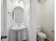 A powder room with pedestal sink, round mirror, and toilet at 2930 E Quiet Hollow Ln, Phoenix, AZ 85024