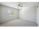 Bright bedroom with a ceiling fan, neutral walls, and a large window at 2930 E Quiet Hollow Ln, Phoenix, AZ 85024