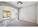 Bright empty room with tile and carpet flooring and a sliding glass door at 2930 E Quiet Hollow Ln, Phoenix, AZ 85024