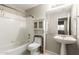 Clean bathroom features a tiled shower, pedestal sink, and built-in storage cabinet at 3152 N 83Rd Pl, Scottsdale, AZ 85251