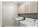 Functional laundry room with washer, dryer, and upper cabinets for storage at 3152 N 83Rd Pl, Scottsdale, AZ 85251