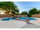 Beautiful backyard pool featuring a rock waterfall, mature trees, and ambient string lights for relaxation at 3152 N 83Rd Pl, Scottsdale, AZ 85251