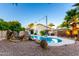 Backyard pool with rock waterfall, relaxing hot tub, and ambient string lights for outdoor enjoyment at 3152 N 83Rd Pl, Scottsdale, AZ 85251