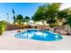 Inviting backyard oasis with a pool, rock waterfall feature, mature palms, and ambient string lights at 3152 N 83Rd Pl, Scottsdale, AZ 85251
