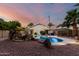 Backyard oasis with a stunning pool, rock features, and sunset views creating a relaxing ambiance at 3152 N 83Rd Pl, Scottsdale, AZ 85251