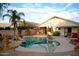 Inviting backyard pool with rock features, lush landscaping, and a covered patio area at 3152 N 83Rd Pl, Scottsdale, AZ 85251