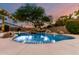Beautiful pool with rock waterfall feature surrounded by lush landscaping and decorative string lights at 3152 N 83Rd Pl, Scottsdale, AZ 85251